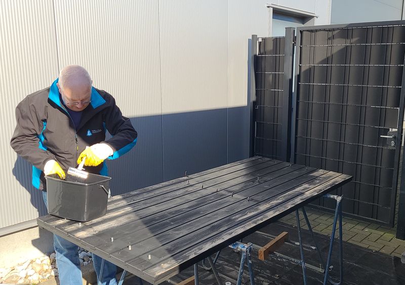 Zwarte beits aanbrengen op tuinhout