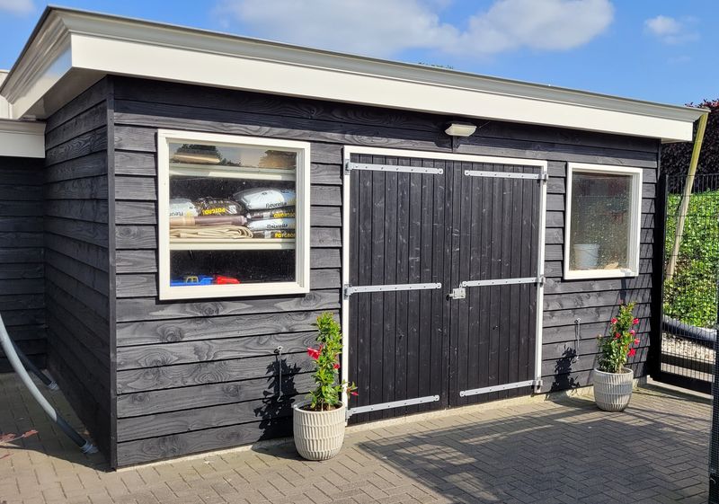 Een tuinschuur zwart beitsen met de zwarte beits gekocht bij Fixza Een tuinschuur zwart beitsen met de zwarte beits gekocht bij Fixza