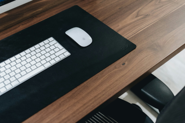 Walnoothout beits kopen? Bekijk het uitgebreide assortiment van Fixza. Walnoot houten bureau met daarop een wit toetsenbord en muis.